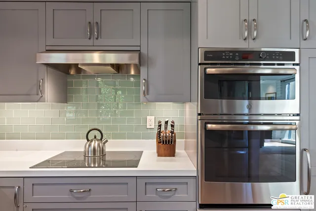a kitchen with granite countertop white cabinets and stainless steel appliances