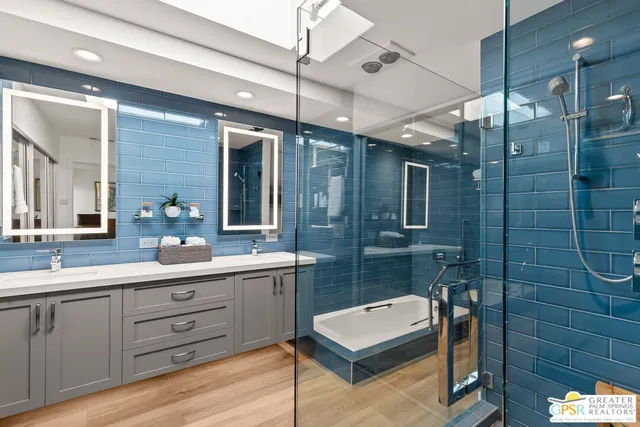 a bathroom with a double vanity sink a toilet a mirror and shower