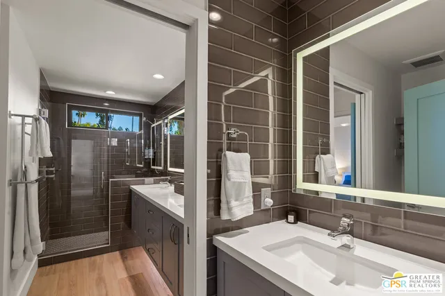 a bathroom with a double vanity sink a mirror and a shower