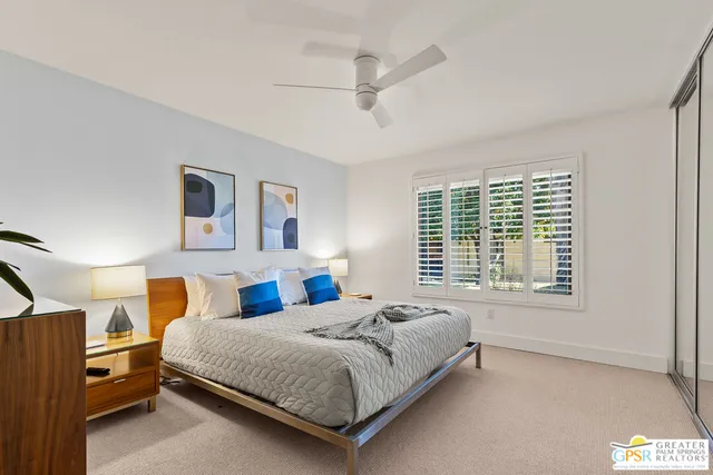 a bedroom with a bed lamp closet and window