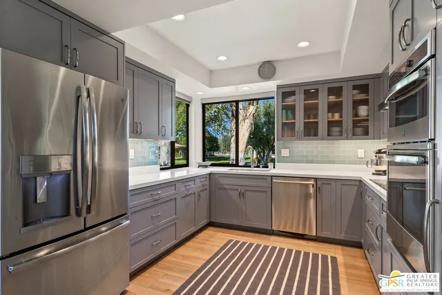 a kitchen with stainless steel appliances granite countertop a refrigerator and a sink