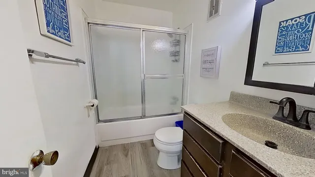 a bathroom with a sink a toilet a shower and a mirror