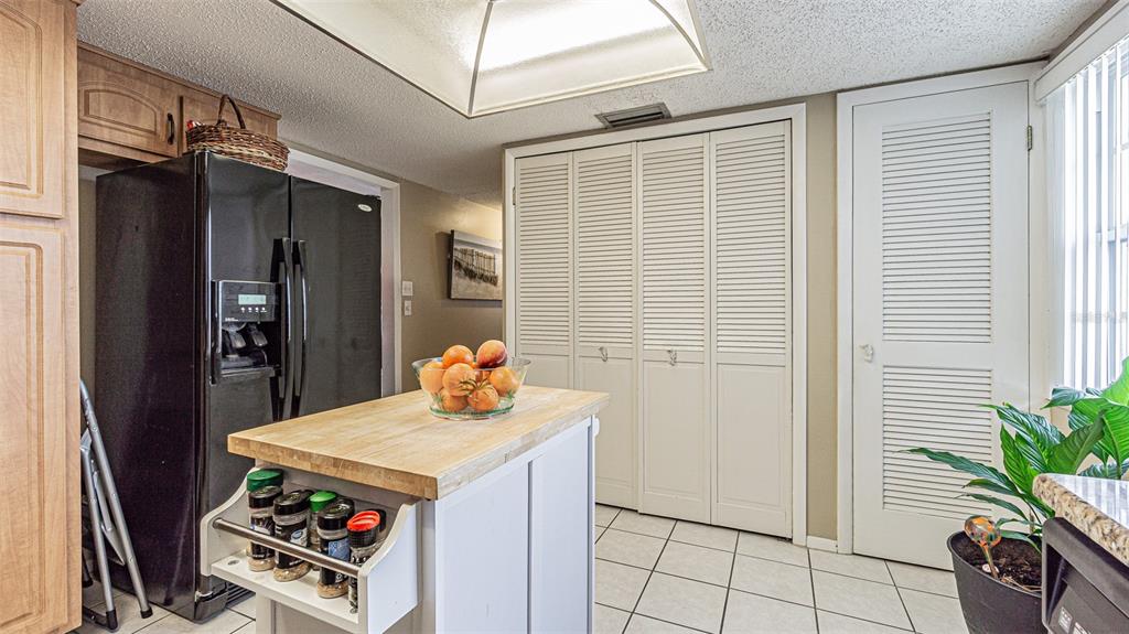 7 Elgin Place, Unit 301 Dunedin, FL 34698 - Photo 12 of 35 a kitchen with stainless steel appliances kitchen island granite countertop a refrigerator and a stove