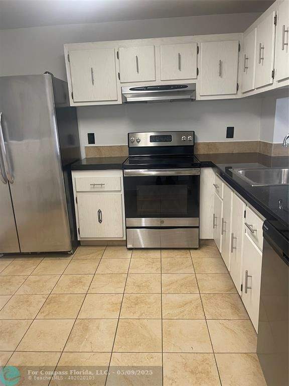 7175 Orange Drive, Unit 216H Davie, FL 33314 - Photo 10 of 14 a kitchen with a stove top oven and cabinets