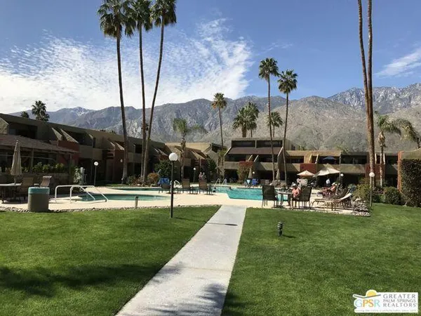 a dining room with wooden floor a chandelier a wooden table and chairs