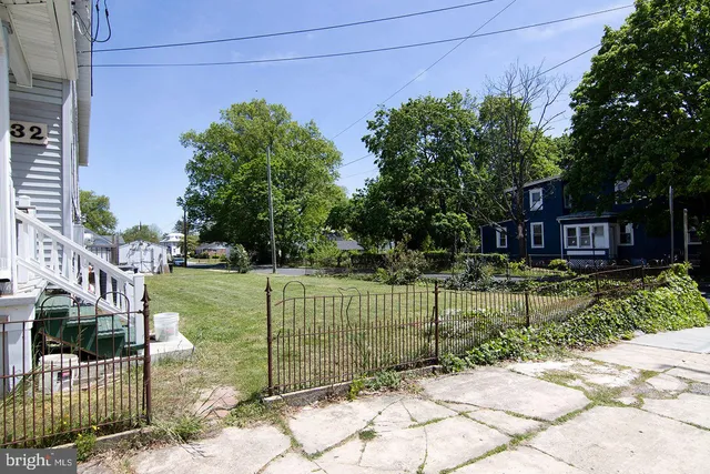 a view of a house with a backyard and a tree