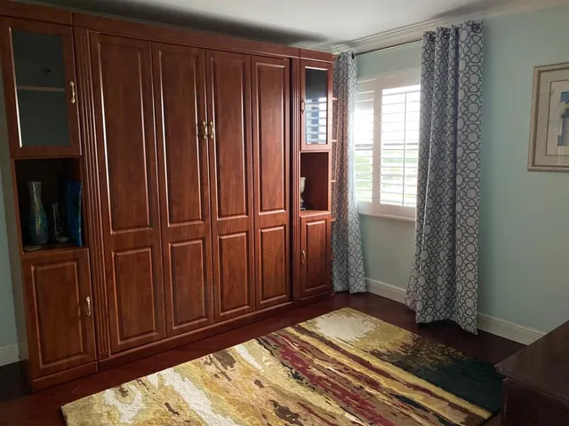 a view of a room with wooden floor closet and windows