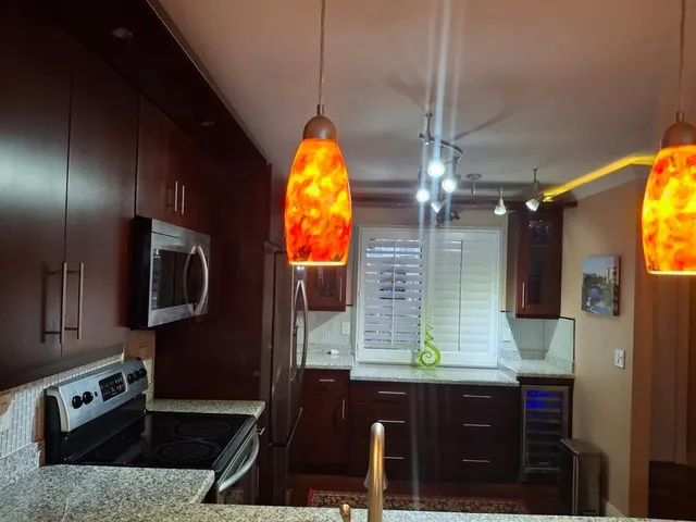 a kitchen with a sink a counter space and chairs
