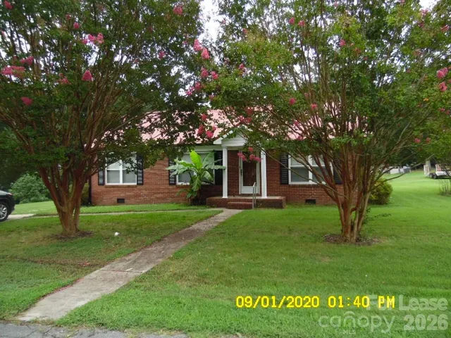 a tree in front of a white house