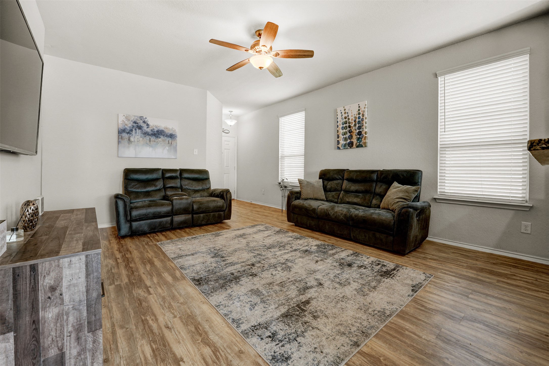 213 Ibis Falls Loop Jarrell, TX 76537 - Photo 5 of 37 A welcoming living room featuring warm-toned wood-look flooring and a functional ceiling fan.