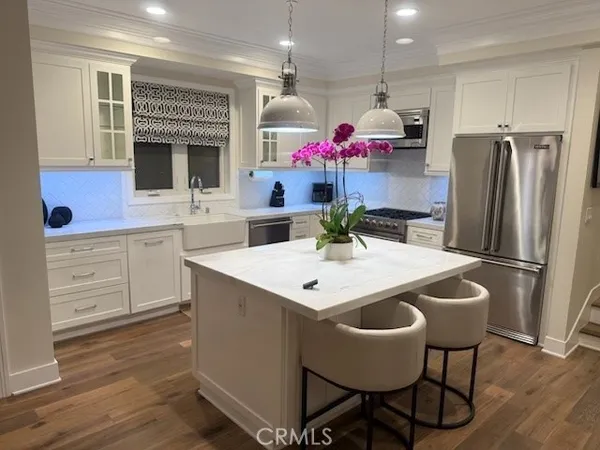a kitchen with granite countertop a sink dining table and chairs