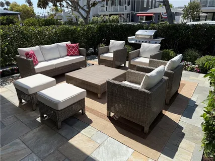 a view of a patio with couches table and chairs and potted plants