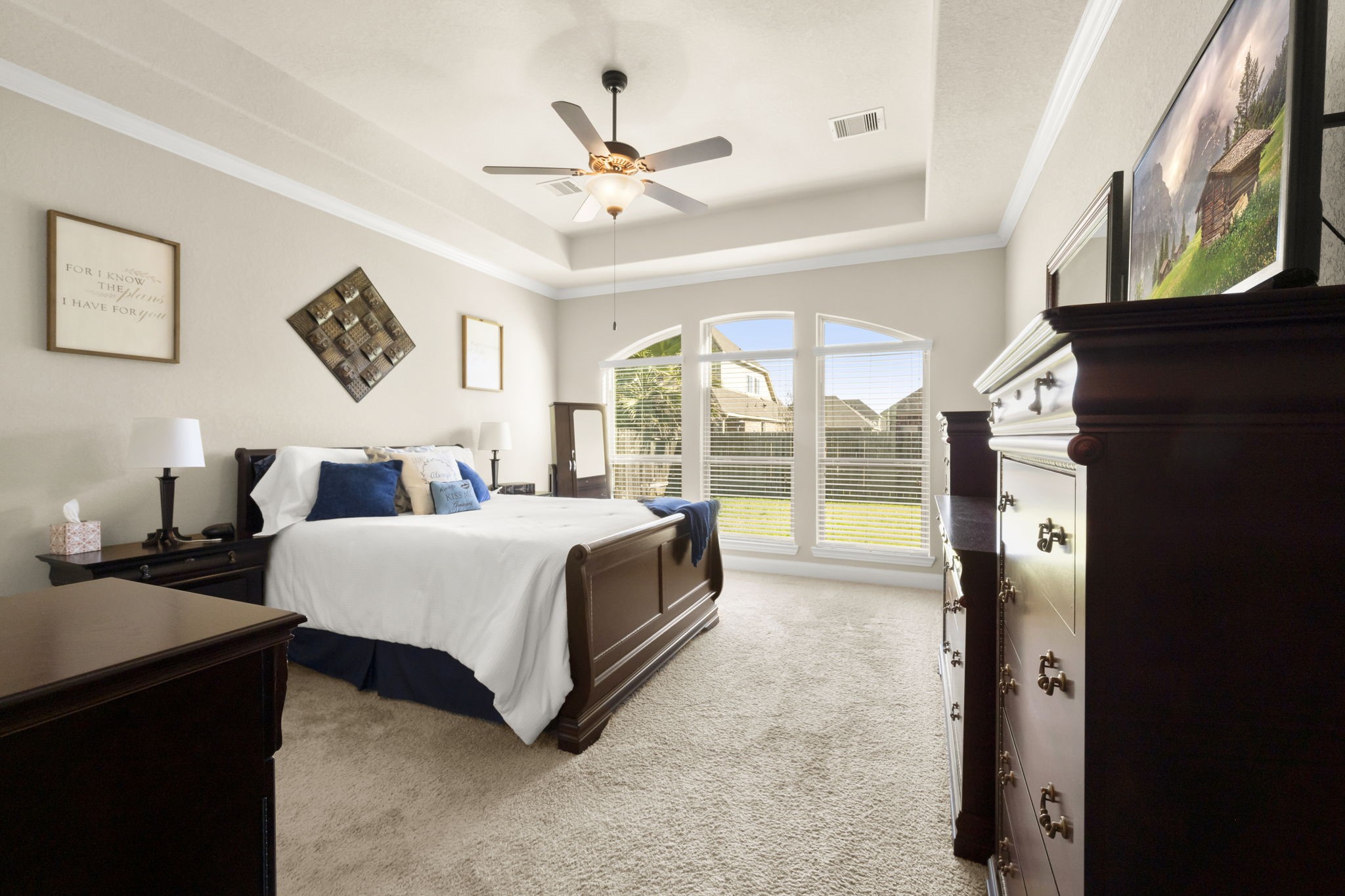 25306 Doyle Sands Court Spring, TX 77389 - Photo 17 of 35 Primary bedroom with arched windows, tray ceilings, crown molding, and abundant natural light for a peaceful retreat.