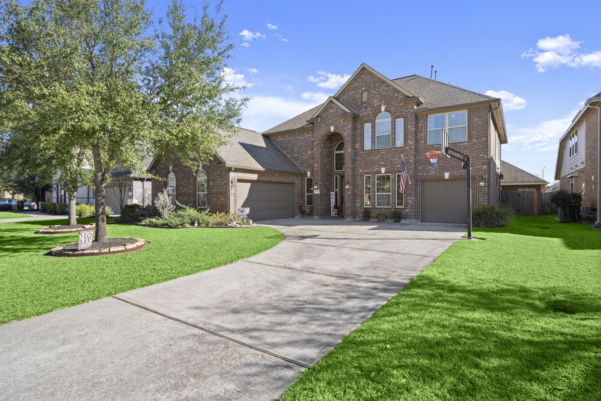 25306 Doyle Sands Court Spring, TX 77389 - Photo 2 of 35 Spacious brick home with a large driveway, three-car garage space, mature trees, and an inviting neighborhood setting.
