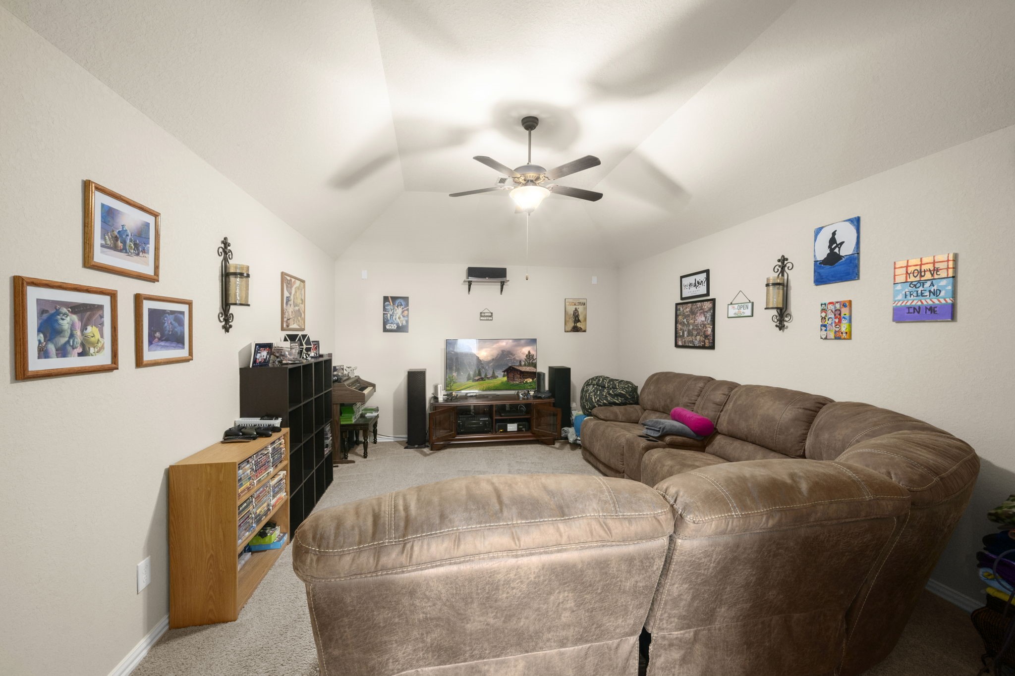 25306 Doyle Sands Court Spring, TX 77389 - Photo 27 of 35 Comfortable movie room with vaulted ceilings, wired for surround sound, perfect for movie nights or relaxing. Sofa will convey with the home.