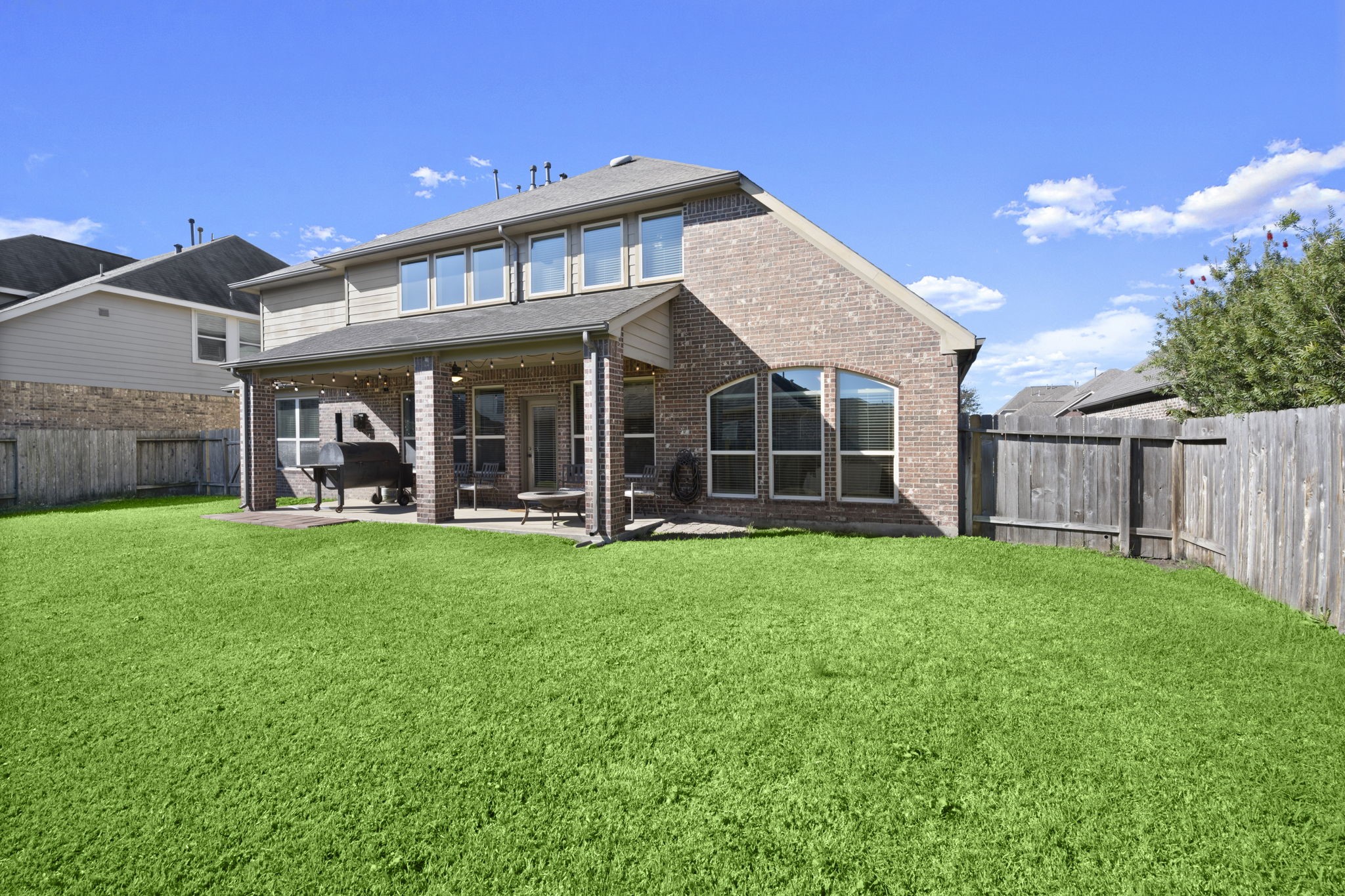 25306 Doyle Sands Court Spring, TX 77389 - Photo 4 of 35 Private backyard with a wide lush lawn and covered patio, ideal for outdoor entertaining and everyday enjoyment.