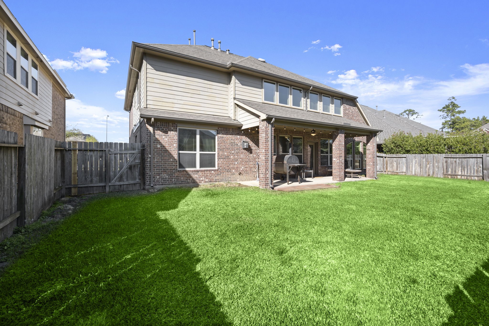 25306 Doyle Sands Court Spring, TX 77389 - Photo 5 of 35 Expansive backyard with mature grass and a covered patio, offering room to add a pool or outdoor kitchen.