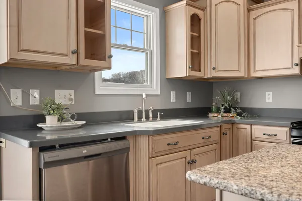a kitchen with stainless steel appliances granite countertop a sink dishwasher a stove and cabinets