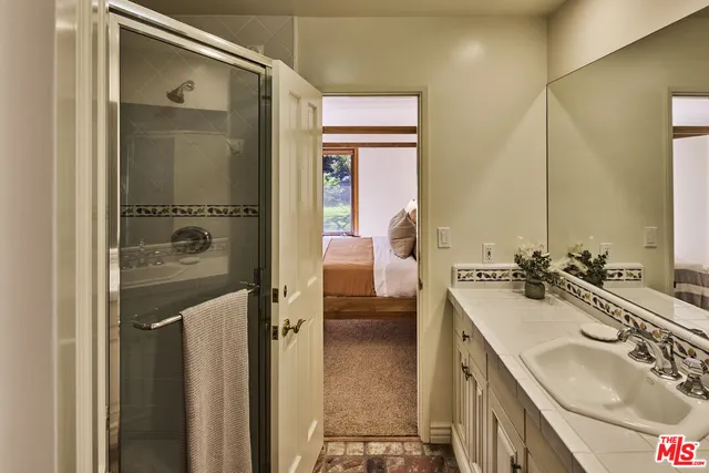 a en suite bathroom with a sink a mirror and a shower
