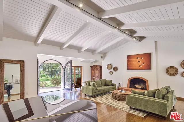 a living room with furniture a fireplace and a large window