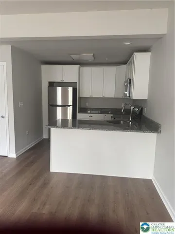 a kitchen with kitchen island a sink stainless steel appliances and cabinets