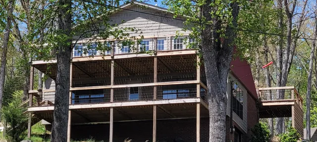 a view of a house with a large window and wooden fence