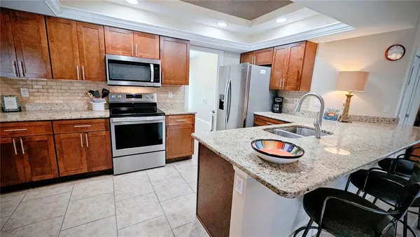 a kitchen with granite countertop a sink and a stove top oven with wooden floor