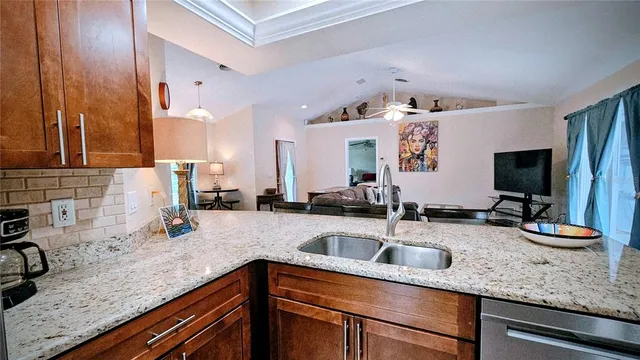 a kitchen with granite countertop a sink and a stove top oven