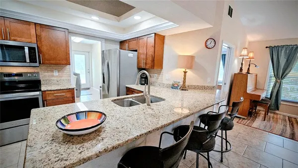 a kitchen with stainless steel appliances granite countertop a stove a sink and a dining table