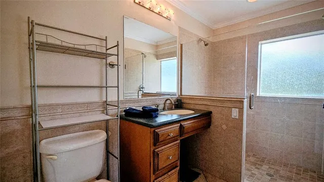 a bathroom with a granite countertop sink a toilet a mirror and shower