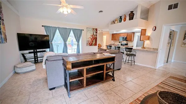 a living room with furniture a flat screen tv and a large window