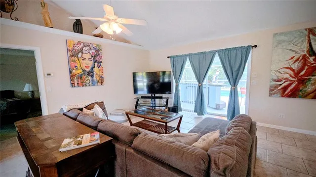 a living room with furniture a flat screen tv and a large window