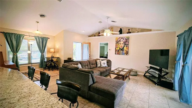 a living room with furniture a flat screen tv and a large window