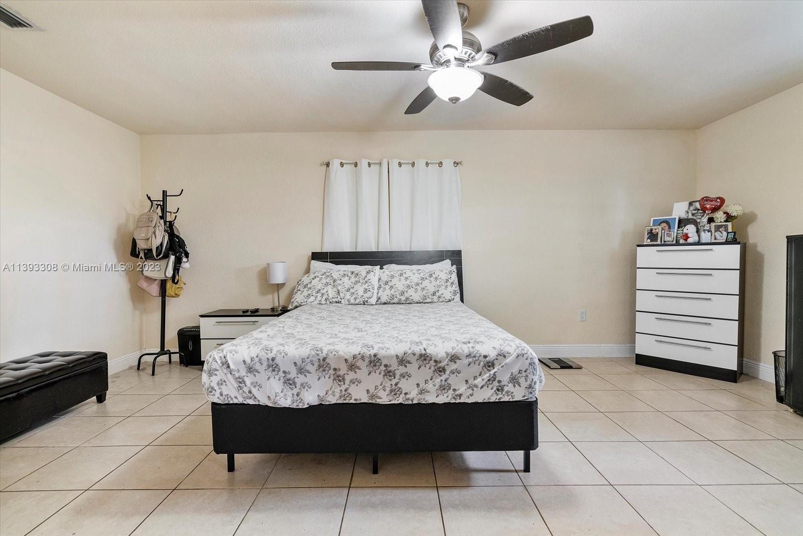 11750 Southwest 223rd Street Miami, FL 33170 - Photo 15 of 28 a bedroom with a bed and a chandelier
