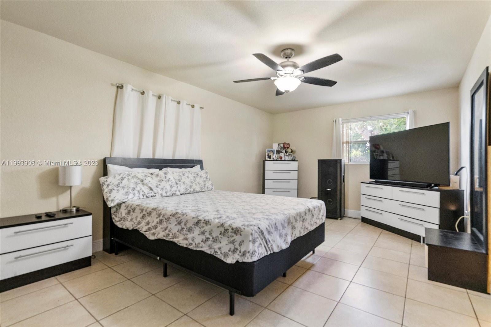 11750 Southwest 223rd Street Miami, FL 33170 - Photo 16 of 28 a bedroom with a bed and a flat screen tv