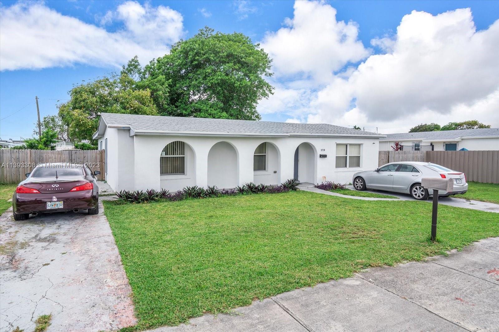 11750 Southwest 223rd Street Miami, FL 33170 - Photo 2 of 28 a front view of a house with a garden