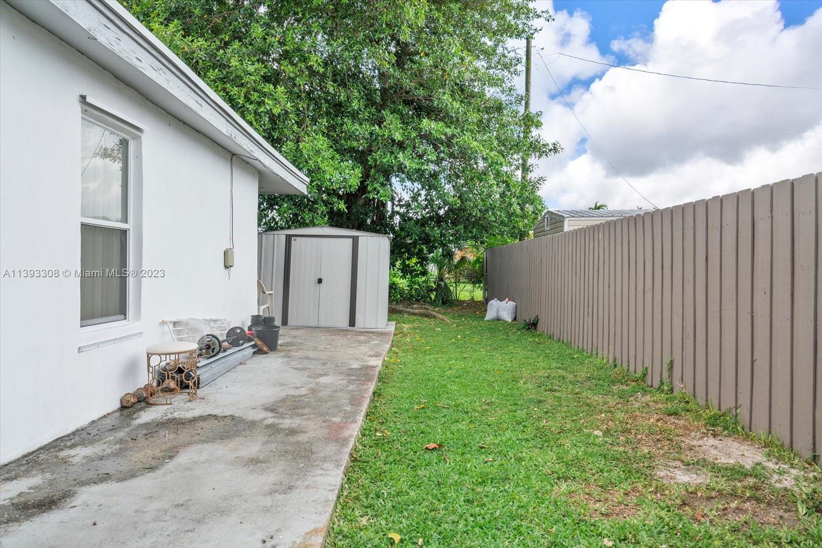11750 Southwest 223rd Street Miami, FL 33170 - Photo 28 of 28 a backyard of a house with plants and tree