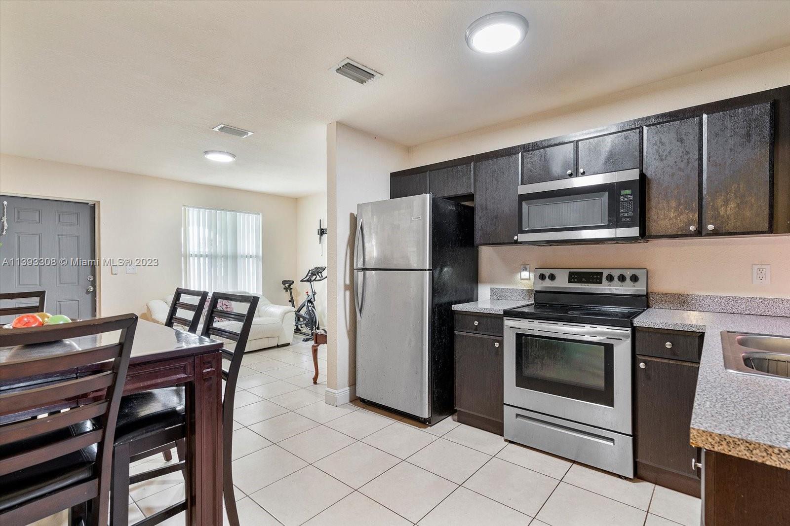 11750 Southwest 223rd Street Miami, FL 33170 - Photo 7 of 28 a kitchen with stainless steel appliances granite countertop a stove a refrigerator a microwave a sink and a refrigerator