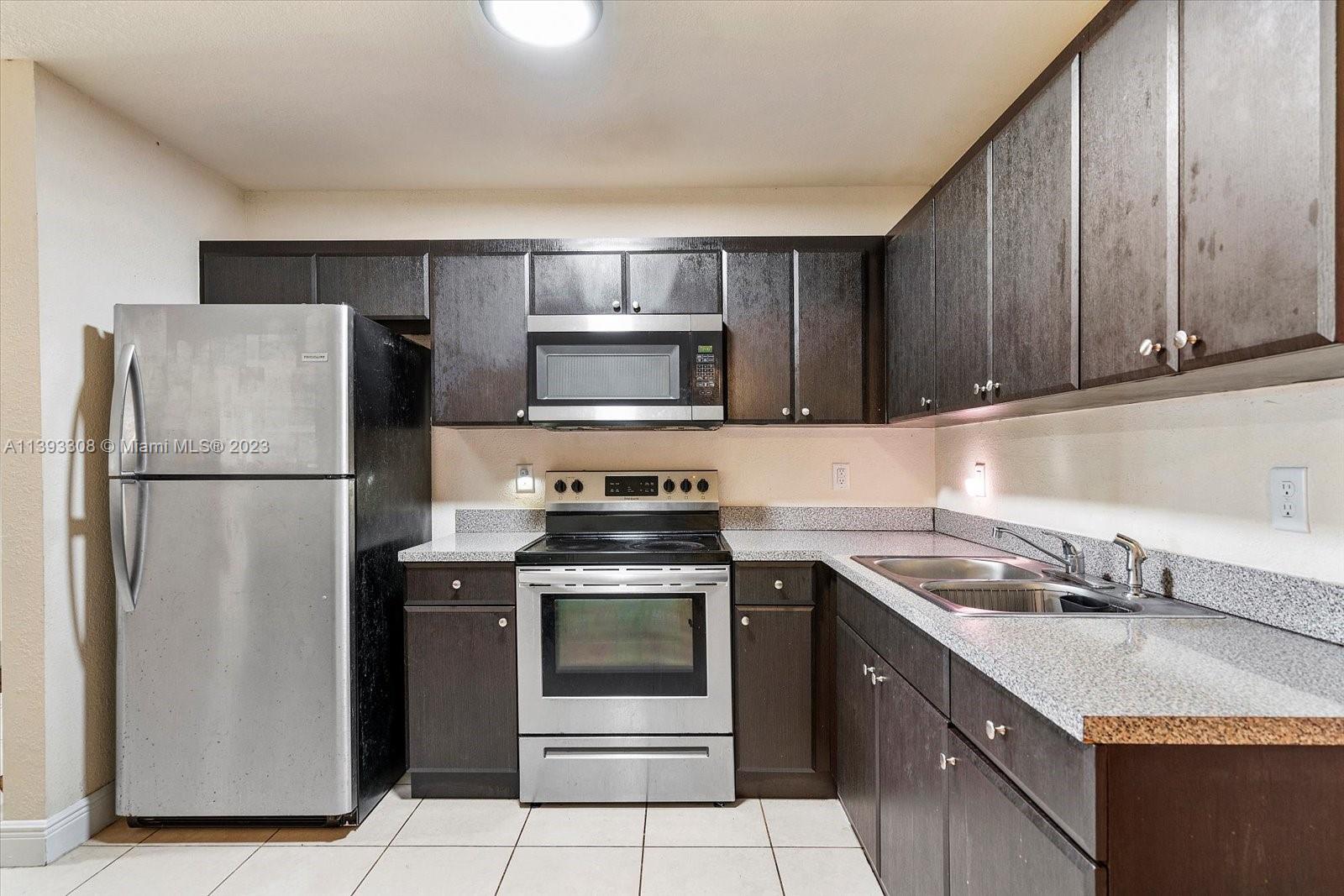 11750 Southwest 223rd Street Miami, FL 33170 - Photo 8 of 28 a kitchen with a sink stove and refrigerator