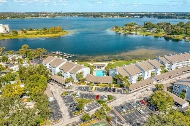 an aerial view of residential houses with outdoor space and lake view