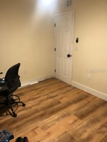 a view of a room with wooden floor and fan