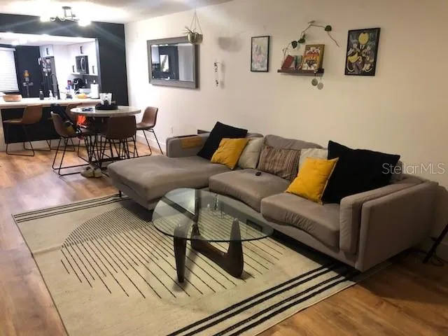 a living room with furniture and wooden floor