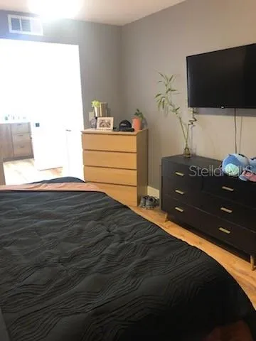 a bedroom with a bed and flat screen tv