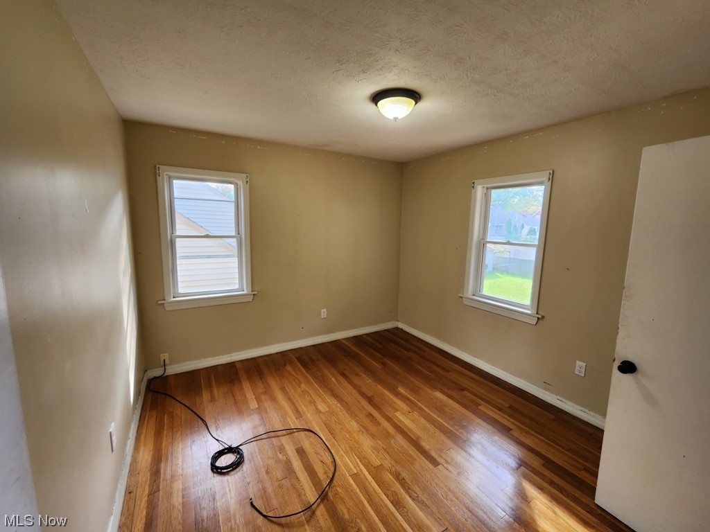 3602 Silsby Road University Heights, OH 44118 - Photo 9 of 19 Wood floored spare room with a textured ceiling