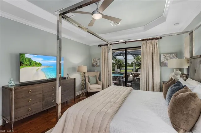 a bedroom with a bed and a flat tv screen on dresser