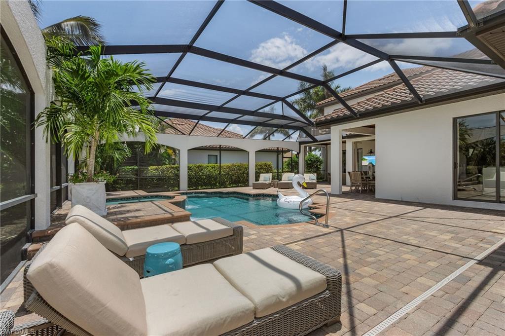 3423 Runaway Court Naples, FL 34114 - Photo 19 of 35 a view of a patio with couches and chairs under an umbrella