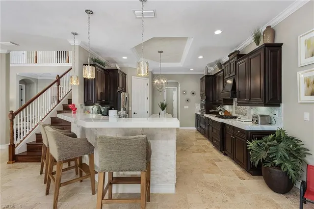 a kitchen with stainless steel appliances kitchen island granite countertop a table chairs in it and wooden floors