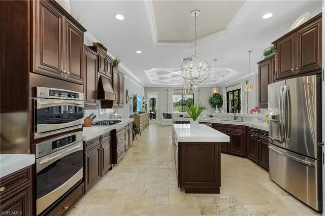a large kitchen with stainless steel appliances kitchen island granite countertop a stove oven and a refrigerator
