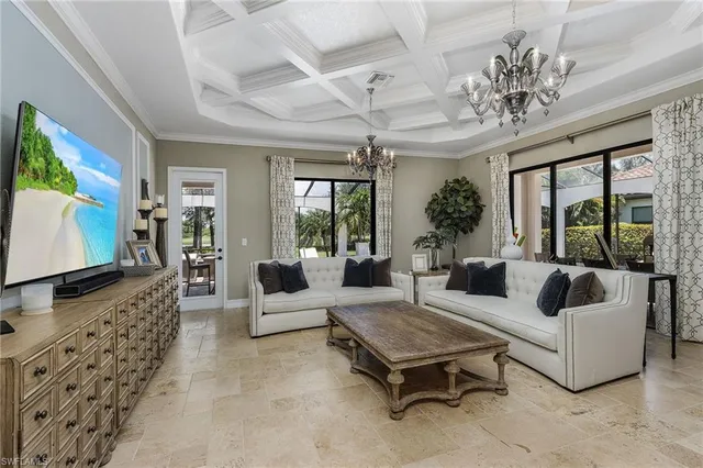 a living room with furniture a chandelier and a flat screen tv