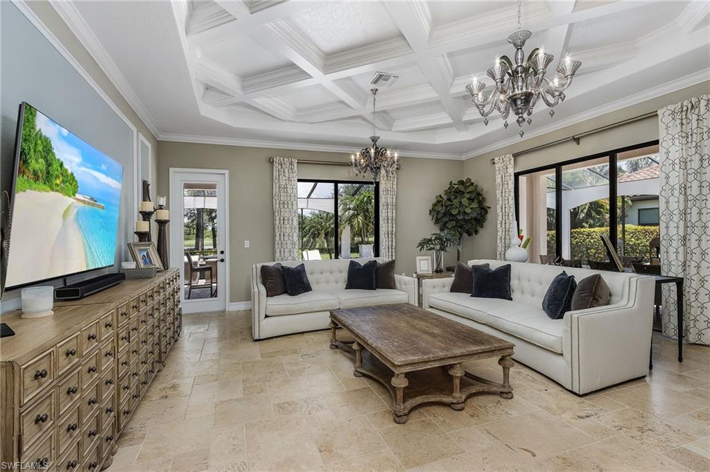 3423 Runaway Court Naples, FL 34114 - Photo 3 of 35 a living room with furniture a chandelier and a flat screen tv
